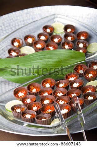 Chocolate cups with red caviar and cream (focus on the lower third)