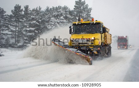 Heavy machinery cleaning road after snowstorm