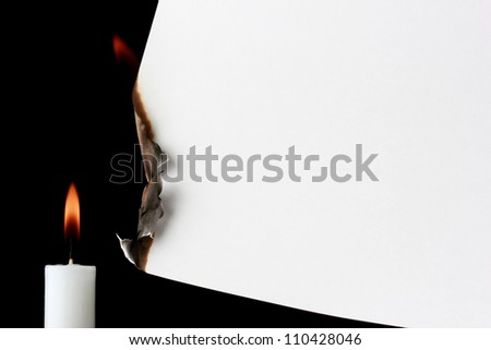 Burning paper with candle on a black background