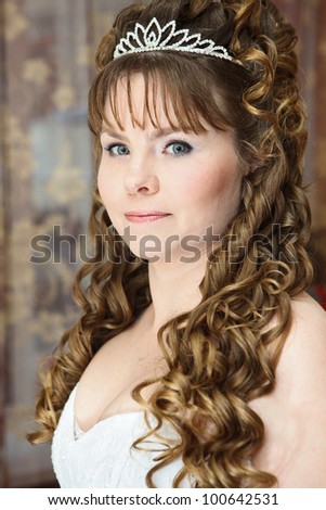 Beauty young Caucasian woman with curly hair and crown on head