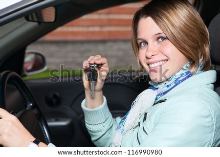 Close up portrait of female driver with car key in hand