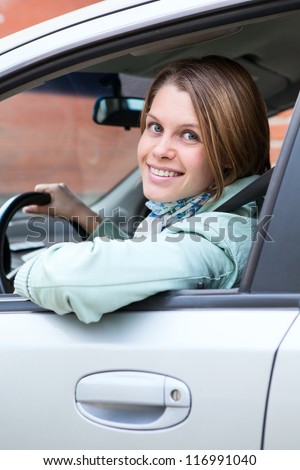 Turning back smiling woman sitting in vehicle