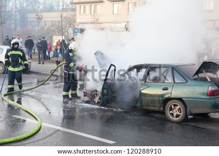 SAINT-PETERSBURG, RUSSIA-NOVEMBER 11: Firefighters extinguish a burning car on city street on November 11, 2012 in Saint-Petersburg, Russia. No one was injured, self-ignition car wiring