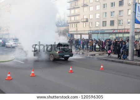 SAINT-PETERSBURG, RUSSIA-NOVEMBER 11: Protection the danger zone near burned car on city street on November 11, 2012 in Saint-Petersburg, Russia. Self-ignition car wiring. No one was injured.