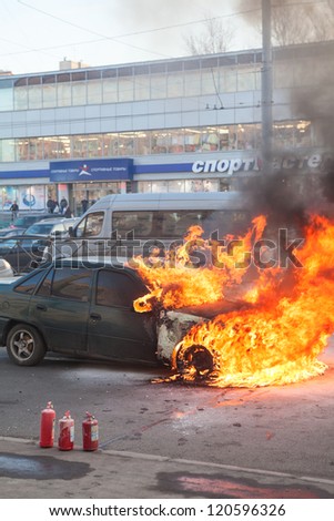 SAINT-PETERSBURG, RUSSIA-NOVEMBER 11: Fire from the car engine hood on city street on November 11, 2012 in Saint-Petersburg, Russia. Self-ignition car wiring. No one was injured.