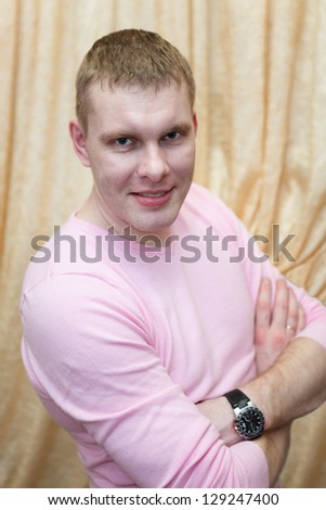 Portrait of handsome blond hair man smiling at camera in pink clothes