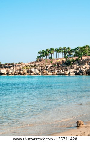 Sandy beach of Cyprus island with rocky seashore at summer