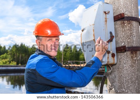 Caucasian senior worker man turning the power switch