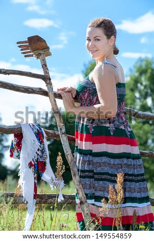 Countrywoman in village resting after manual work in summer sunny day