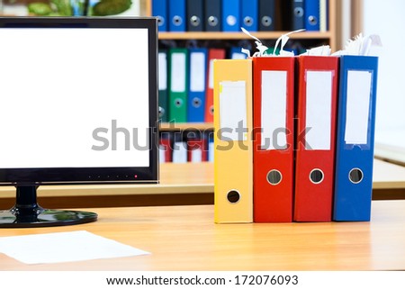 Part of the screen monitor isolated and colored folders for papers on the table