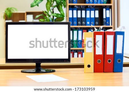 Isolated monitor screen and colored folders for papers on the table