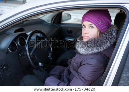 Woman in winter clothes sitting in his car