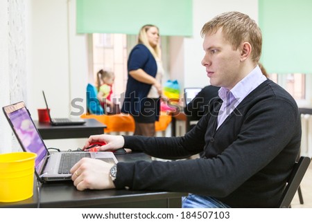 Young man working with laptop in co-working room