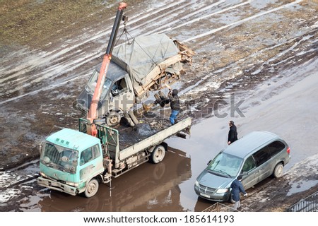 SAINT-PETERSBURG, RUSSIA - CIRCA FEBRUARY, 2014: Tow truck loads banding after road crash freight car for scrappage. Government scrappage scheme