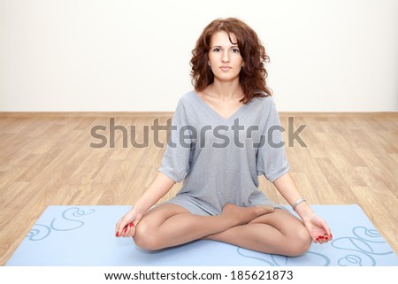 Woman meditating in the lotus position with opened eyes