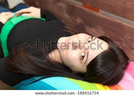 Young woman with long hair laying back and looking at camera