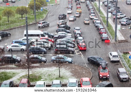 Vehicles parking on street and strong rain with snow