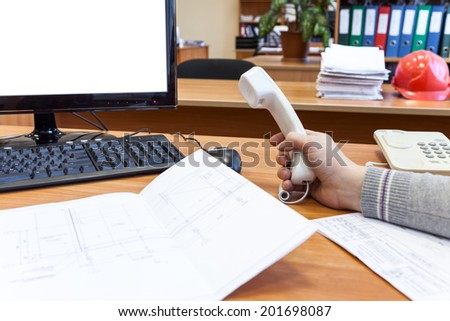 Engineer at the work with telephone in hand