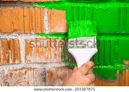 Close up view of hand with paint brush in green color