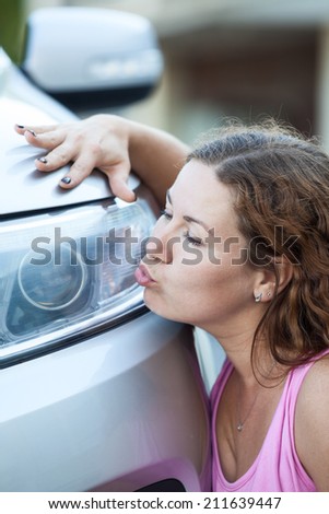 Young woman kissing her new car