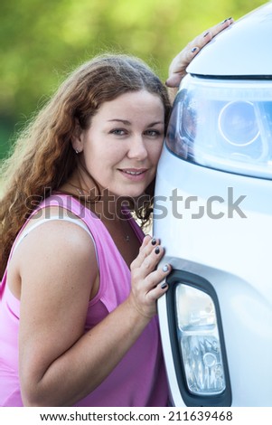 Appeasement woman in pink blouse leaning her cheek to the car