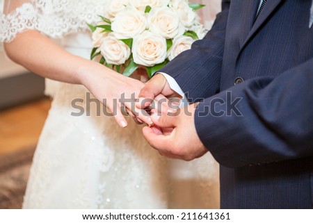 Man wearing wedding ring on bride`s finger