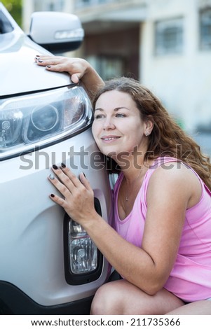 Young Caucasian woman adoring her new car