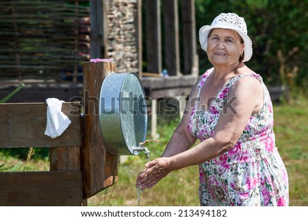 Mature woman washes her hands at country residence