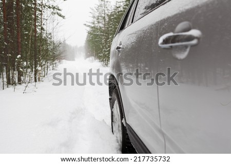 Offroad car on snowy forest road, side view