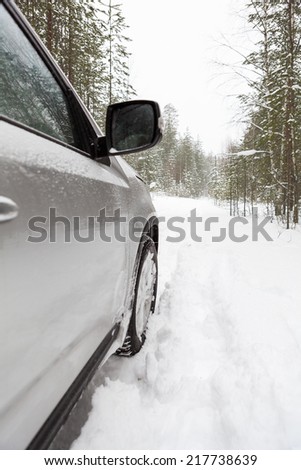 Offroad car on snowy forest road, side view point