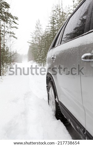 Car on a snowy forest road, side view