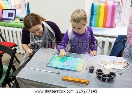 Child drawing with needle on the water. Ebru art is a method of aqueous surface design