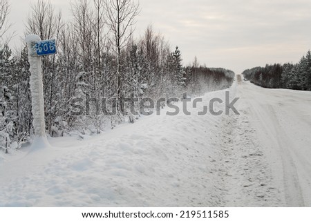 Road sign kilometer post in northern snowing road. Russia. Winter