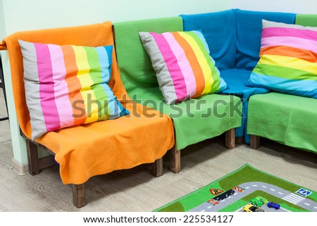 Corner sofa with colorful striped pillows in the room