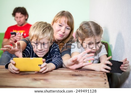 Mom trying to grab smartphones in children hands