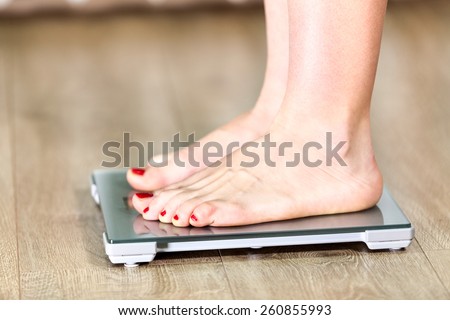 Close up of Caucasian woman with bare feet is on floor weight scales