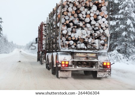SEGEZHA, KARELIA, RUSSIA - CIRCA DEC, 2014: Timber transporter truck is on the Kola highway in winter season. The Kola is a federal road from St. Petersburg to Murmansk