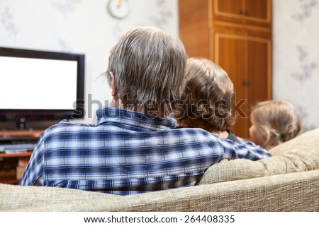 Caucasian family from three people sitting on the sofa and watching tv set, rear view, isolated white screen