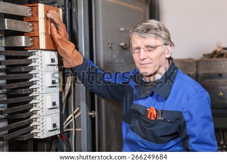 Electrician worker in rubber glove take on switches