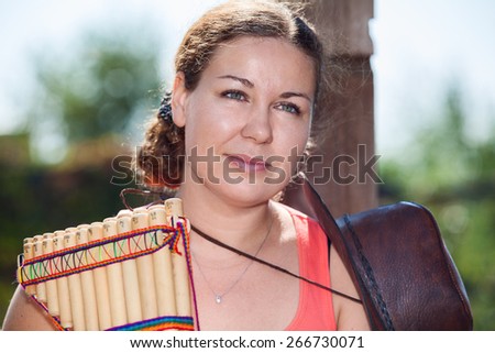 Young country woman with cowboy hat with panpipe