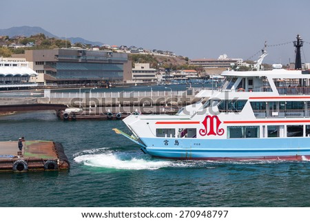 MIYAJIMAGUCHI, JAPAN - CIRCA APR, 2013: The ferry of Matsudai Kisen company moors to Miyajimaguchi town pier. Two ferry-boats for Itsukushima island travel. The Hiroshima gulf, Japan.