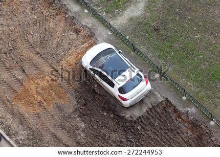ST. PETERSBURG, RUSSIA - CIRCA APR, 2015: Wrong parking vehicle is on middle of lawn while construction machinery works for extension of parking area of building. Creation of living environment