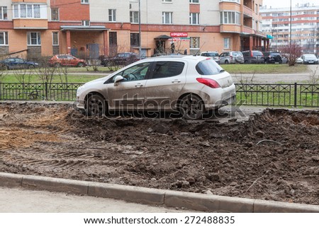 ST. PETERSBURG, RUSSIA - CIRCA APR, 2015: Wrong parking car is on middle of lawn while construction machinery works for extension of parking area of apartment building. Creation of living environment