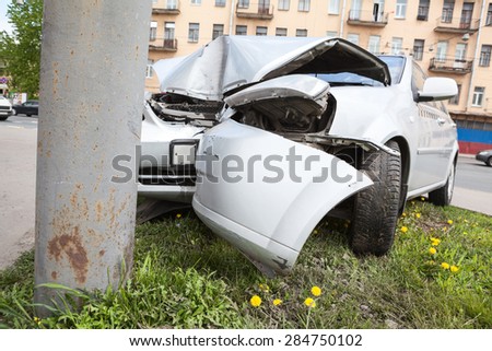 Broken bumper and hood of vehicle as a result of a collision with a pole, close-up. The accident at the crossroads