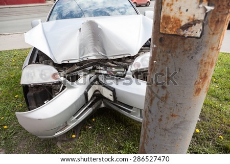 Broken bumper and hood of the car as a result of a collision with a pole, close-up. The accident at the crossroads