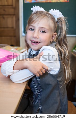 Smiling first grade schoolgirl portrait, girl in uniform