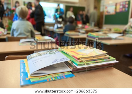 ST. PETERSBURG, RUSSIA - CIRCA SEPTEMBER, 2014: School exercise and ABC books are on the desk in classroom. Parents with kids are indoor. Children go back to school at first time in September