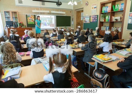 ST. PETERSBURG, RUSSIA - SEP, 1, 2014: First-grade students and teacher are in school classroom at first lesson. Children go back to school at first time in September