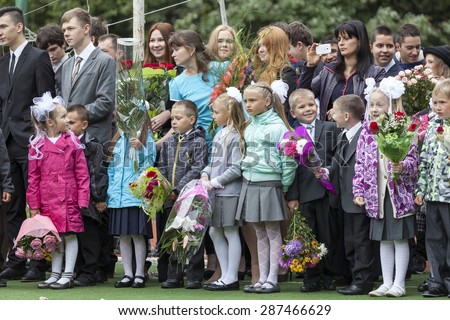 ST. PETERSBURG, RUSSIA - SEP, 1, 2014: School line is in schoolyard with first-grade pupils and teacher. Children go back to school at first time in September