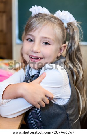Smiling first grade schoolgirl portrait, Caucasian girl smiling and looking at camera